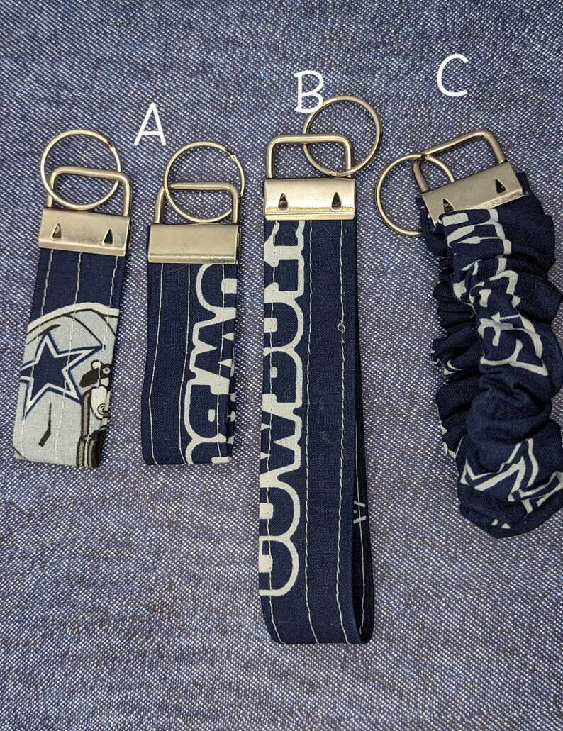 Pu&ograve; includere: Tre diversi stili di portachiavi dei Dallas Cowboys. Il primo portachiavi &egrave; in tessuto blu e bianco con una stella e un cowboy a cavallo. Il secondo portachiavi &egrave; in tessuto blu con la parola "Cowboys" ripetuta in bianco. Il terzo portachiavi &egrave; in tessuto blu e bianco con uno stile scrunchie.