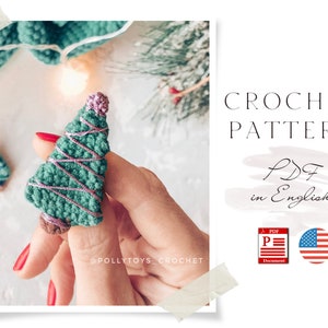 May include: Crochet pattern for a small green Christmas tree with pink yarn accents. The pattern is available as a PDF in English. The image shows a hand holding the finished crochet tree.