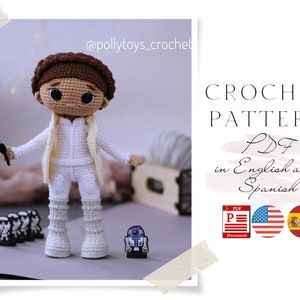 May include: Crochet pattern PDF in English and Spanish for a white crocheted doll with brown hair, holding a blue lightsaber. The doll is standing next to a small, white crocheted robot. The pattern is available in both English and Spanish.