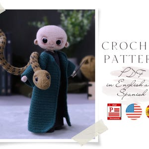 Puede incluir: Patrón de crochet PDF en inglés y español para una muñeca amigurumi de crochet verde con una serpiente envuelta alrededor de su brazo. La muñeca tiene una cara marrón claro con ojos negros y una boca negra. La serpiente es marrón con una cabeza marrón claro. El patrón está disponible en formato PDF.