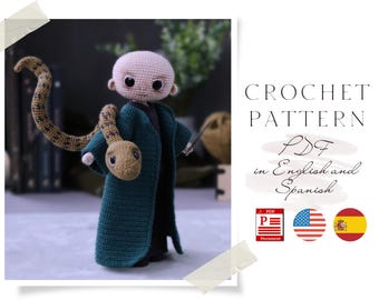 May include: Crochet pattern PDF in English and Spanish for a green crocheted amigurumi doll with a snake wrapped around its arm. The doll has a light brown face with black eyes and a black mouth. The snake is brown with a light brown head. The pattern is available in PDF format.