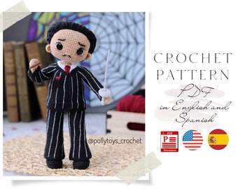 May include: Crochet pattern PDF in English and Spanish for a black and white striped amigurumi doll wearing a red tie. The doll is holding a small white object in its right hand and a long white stick in its left hand. The doll is standing on a woven surface. @pollytoys.crochet