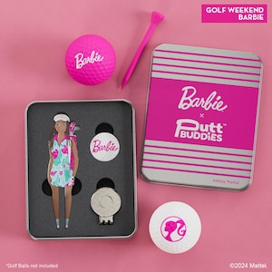 May include: A pink and silver tin with a Barbie logo and the text "Golf Weekend Barbie" on the top. The tin contains a golf ball, a golf ball marker, a golf tee, and a golf club with a Barbie doll figure attached. The tin is on a pink background.