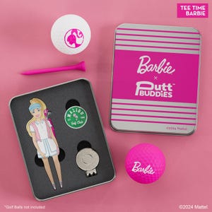 May include: A pink and silver tin with the text "Barbie x Putt Buddies" and the year "2024 Mattel." The tin contains a pink golf ball with the word "Barbie" on it, a golf ball with a Barbie doll image, a golf tee, and a golf ball retriever.