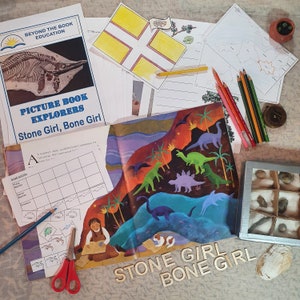 May include: A colorful children's book titled "Stone Girl, Bone Girl" with illustrations of dinosaurs and a girl with a magnifying glass. The book is open to a page with a chart titled "Graph Activity" and a section labeled "A".