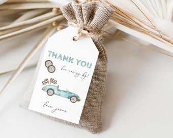 Peut inclure: Étiquette de remerciement blanche avec une illustration aquarelle bleue et verte d'une voiture de course avec des drapeaux à damier et le texte "Merci d'être venu Love Jessam". L'étiquette est attachée à un petit sac en toile de jute brun.