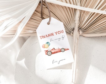 Peut inclure: Une étiquette de remerciement blanche avec du texte rouge qui dit "Merci d'être venu courir !" avec une voiture de course rouge avec des ballons sur le dessus. Le texte "love, Jason" est écrit en noir en bas de l'étiquette.