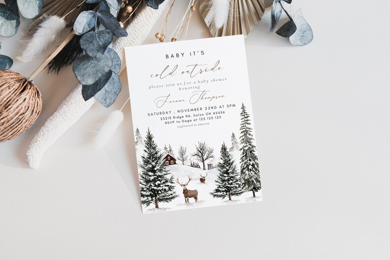 K&ouml;nnte beinhalten: Eine Babyparty-Einladung im Winter-Design mit einer Aquarell-Illustration einer verschneiten Waldszene. Der Text lautet "Baby It's Cold Outside" und enth&auml;lt Details zur Veranstaltung, wie Datum, Uhrzeit und Ort.