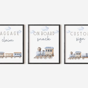 May include: Three printable signs with a blue train illustration and white text. The signs read "Baggage Claim", "On Board Snack", and "Custom Sign".