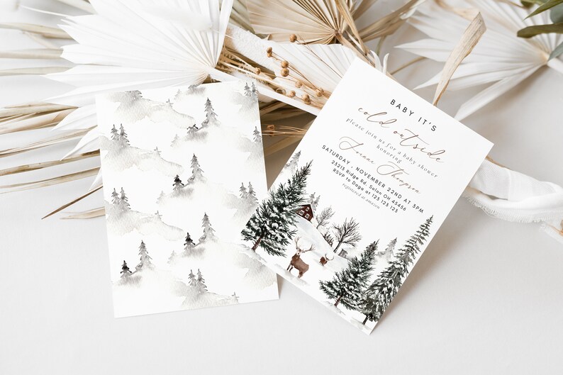 K&ouml;nnte beinhalten: Eine Babyparty-Einladung mit einem Winterwunderland-Thema. Die Einladung zeigt eine Aquarell-Illustration eines verschneiten Waldes mit einer H&uuml;tte und einem Reh. Der Text auf der Einladung lautet "Baby It's Cold Outside" und enth&auml;lt das Datum und die Uhrzeit der Party.