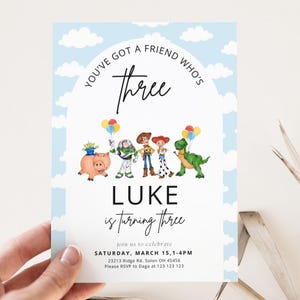 May include: A light blue birthday invitation with a cloud design and the text "YOU'VE GOT A FRIEND WHO'S Three". The invitation features illustrations of characters from the movie Toy Story and the text "LUKE is turning three".