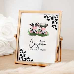 May include: A printable 8x10 sign template featuring two adorable cartoon cows with floral crowns and black and white cow print accents. The text "Custom 8 x 10 Sign Template" is printed below the cows.