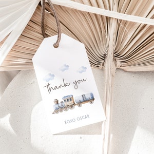 May include: A white thank you tag with a blue and brown train illustration. The tag says "Thank you" and "XOXO Oscar".