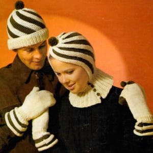 May include: Two people wearing matching knitted winter hats, gloves, and a neck warmer. The hats and gloves have a striped pattern in cream and dark brown. The neck warmer has a cream color with brown buttons.