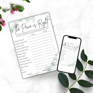 Green leaves on a white marble countertop. Baby shower The Price Is Right game 5x7 printout on the counter. Phone also on the counter with same Price is Right game displayed on it.