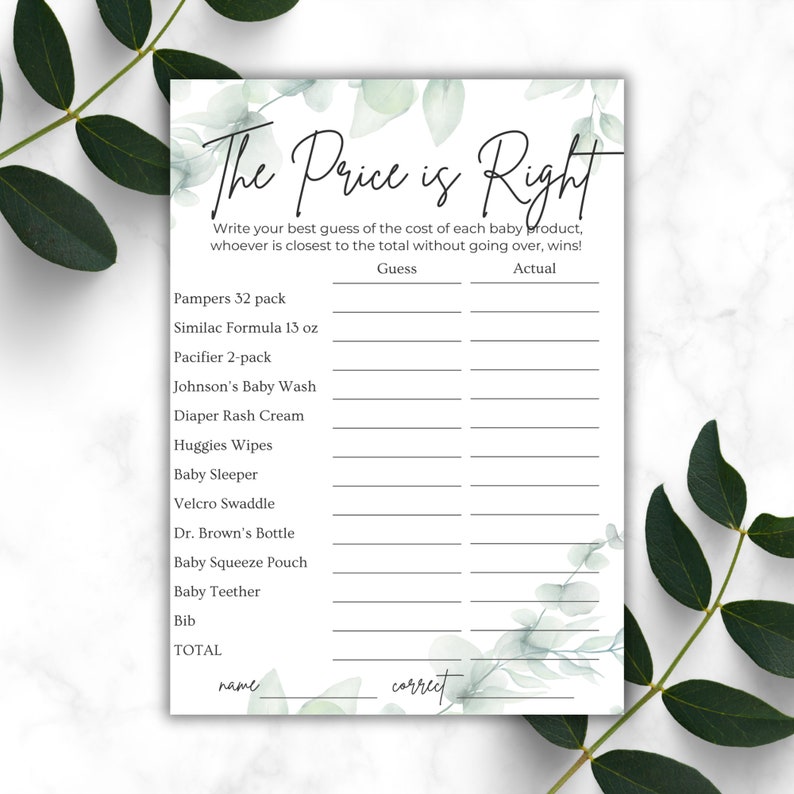 Green leaves on a white marble countertop. Baby shower The Price Is Right game 5x7 printout on the counter
