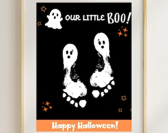 May include: A framed Halloween-themed print with a black background. The print features white footprints resembling ghosts, the phrase "OUR LITTLE BOO!", a ghost illustration, and the text "Happy Halloween!" in orange.