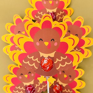 May include: A set of five paper turkey lollipop holders with red, yellow, and brown accents. Each turkey has a hole in the back to hold a lollipop. The turkeys are on sticks.