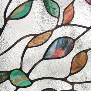 May include: A stained glass window design featuring a pattern of leaves in shades of green, brown, and blue on a white background.