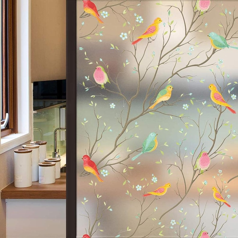May include: Frosted window film with a design of colorful birds perched on branches with white flowers. The birds are red, yellow, blue, and pink.