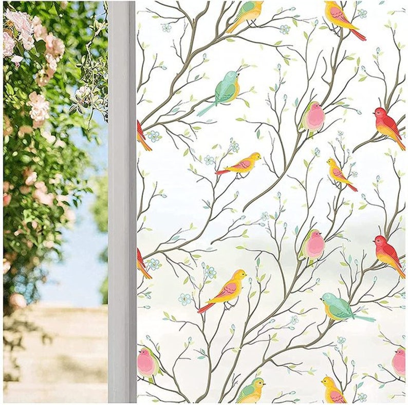 May include: A white window film with a repeating pattern of colorful birds on branches. The birds are yellow, red, blue, and pink.