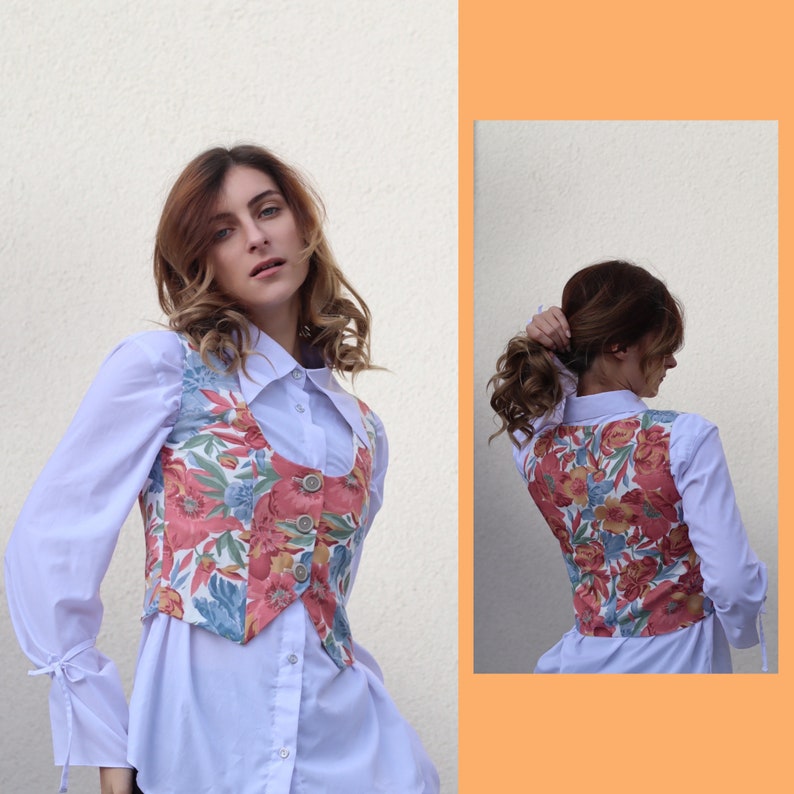 May include: A white button-down shirt with a floral print vest. The vest has a scoop neck and a button closure. The shirt has long sleeves and a collar.