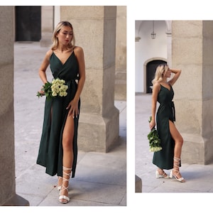 Puede incluir: Una mujer lleva un vestido maxi verde oscuro con una abertura en el muslo y un cintur&oacute;n blanco. Lleva un ramo de rosas blancas y tacones blancos de tiras.