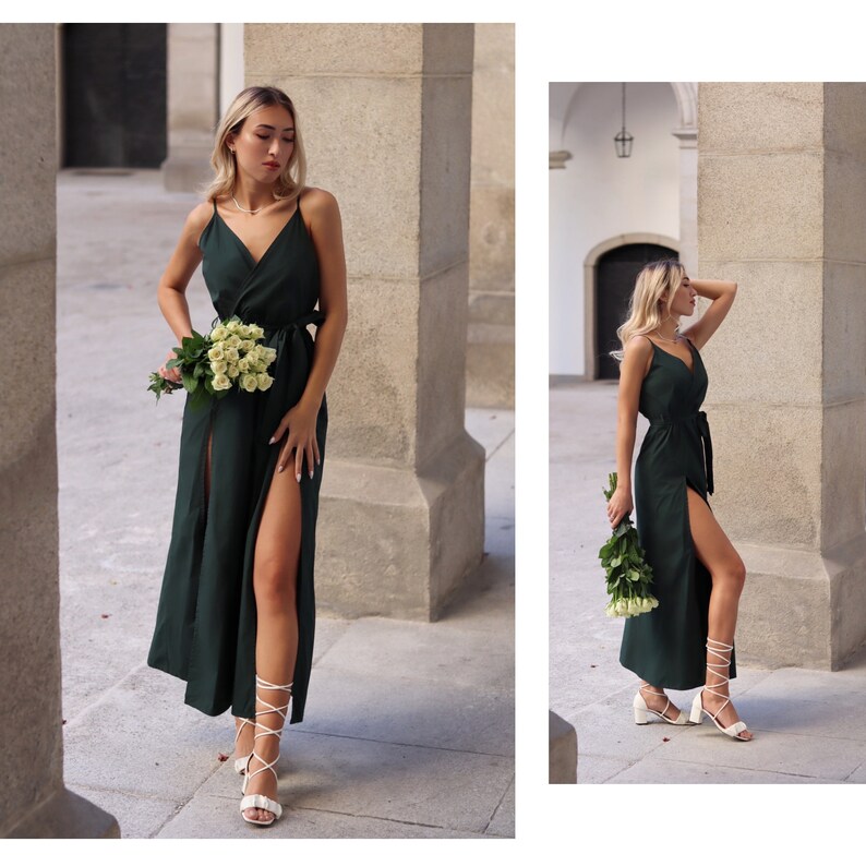 Puede incluir: Una mujer lleva un vestido maxi verde oscuro con una abertura en el muslo y un cintur&oacute;n blanco. Lleva un ramo de rosas blancas y tacones blancos de tiras.