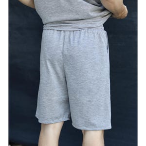May include: Gray shorts with an elastic waistband. The shorts are made of a soft, knit fabric. The shorts are knee-length and have a relaxed fit. The shorts are part of a matching set with a gray t-shirt.