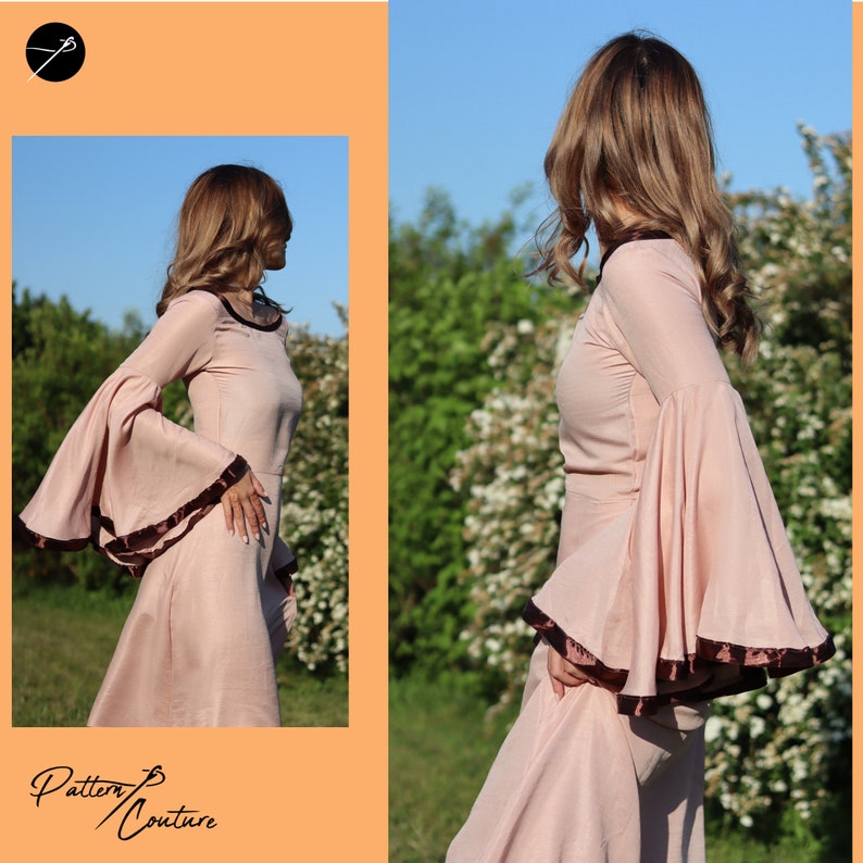 Op de afbeelding: Een vrouw draagt een lange, roze jurk met wijde mouwen en een bruine bies. De jurk heeft een getailleerd bovenstuk en een zwierige rok. De vrouw staat op een veld met groen gras en bomen op de achtergrond.