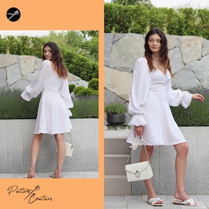 May include: A white dress with long sleeves and a gathered skirt. The dress has a square neckline and a fitted bodice. The model is wearing the dress with a white handbag and white sandals.