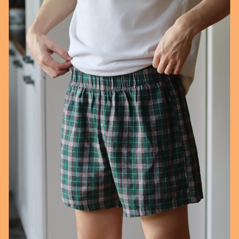 May include: Green and brown plaid pajama shorts with an elastic waistband.