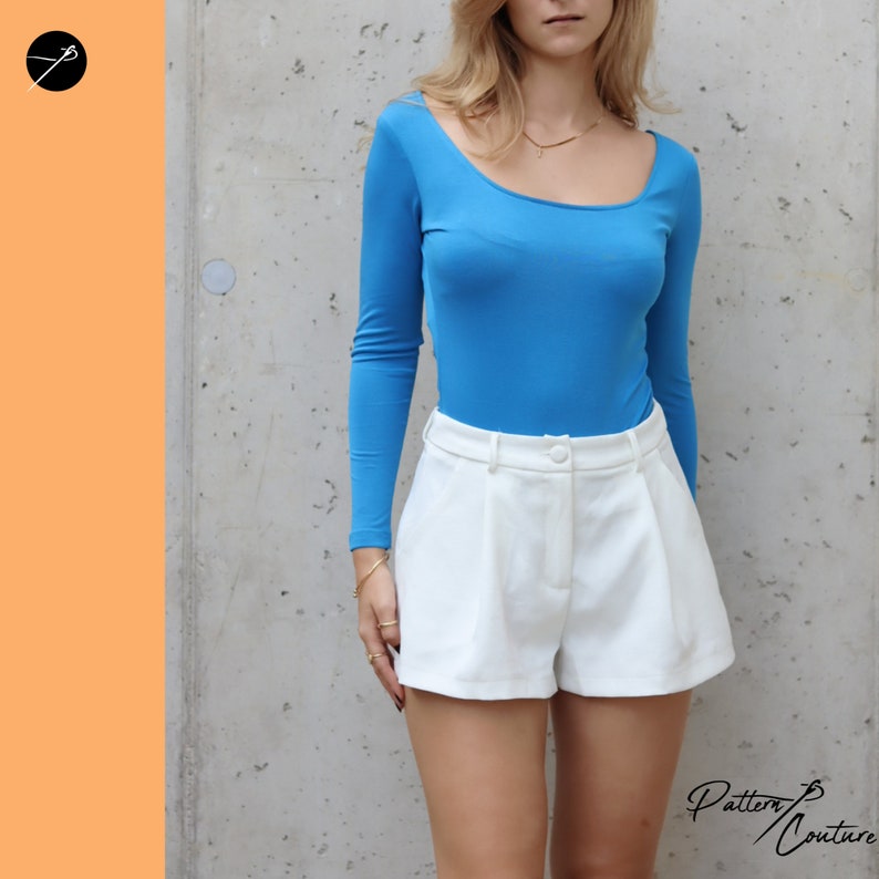 May include: A woman wearing a bright blue long-sleeved top and white high-waisted shorts. The top has a scoop neckline.