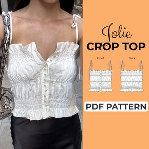 May include: A white crop top featuring a shirred bodice, thin tie-shoulder straps, and a front button placket with small pearl-like buttons. The image includes text reading Jolie CROP TOP and PDF PATTERN with front and back technical sketches.