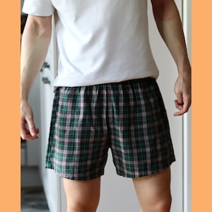 May include: Green and brown plaid pajama shorts with a white waistband.