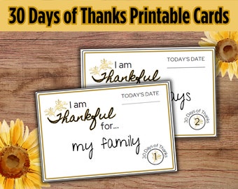 Może przedstawiać: Dwie karty do druku z tekstem "I am Thankful" i "30 Days of Thanks". Karty mają złote obramowanie i kwiatowe akcenty. Jedna karta mówi "I am Thankful for... my family."