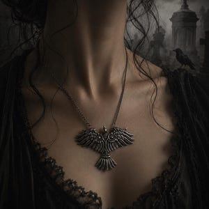 May include: A silver-toned metal pendant necklace featuring a stylized bird with outstretched wings and intricate feather detailing. The pendant is suspended from a thin metal chain and displays a symmetrical design with a small knotwork element.