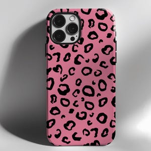 May include: A pink phone case with a black leopard print design. The case has a cutout for the camera lens.