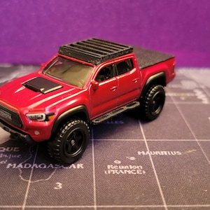 Custom Overland Toyota Tacoma Hot Wheels RED with roof rack, rock sliders, and bed cover