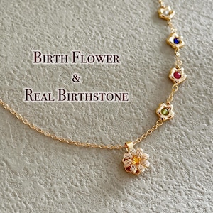 May include: A gold necklace with a flower pendant and five smaller flower charms with birthstones. The text "Birth Flower & Real Birthstone" is displayed on the image.