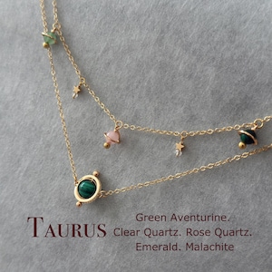 Può includere: Collana d'oro con un ciondolo in malachite verde, una pietra di quarzo rosa e una pietra di quarzo trasparente. La collana presenta anche piccole stelle dorate e la parola "TAURUS" in lettere dorate. Aventurina verde. Quarzo trasparente. Quarzo rosa. Smeraldo. Malachite.