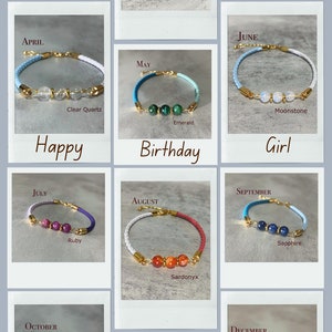 May include: Twelve colourful bracelets with gold accents and gemstone beads. Each bracelet represents a different month of the year. The bracelets are arranged in a grid with the month name and gemstone name below each bracelet.