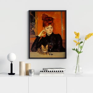 May include: A framed painting depicting a woman with red hair seated at a table with a cat and a glass of red wine. The woman is wearing a black dress and the cat is brown and white.