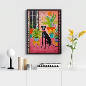 May include: A painting of a black dog sitting in a room with plants and a pink tiled floor. The dog is wearing a black collar. The painting is framed in black.