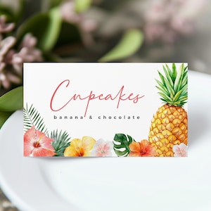 Pode incluir: Um cartão branco com a palavra "Cupcakes" em escrita rosa e "banana & chocolate" em uma fonte menor. O cartão apresenta um abacaxi em aquarela, flores tropicais e folhas verdes.