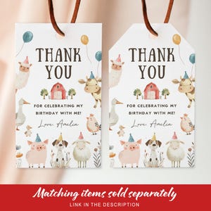 May include: Two white gift tags with brown string feature a farm animal theme. The tags say "THANK YOU" and "FOR CELEBRATING MY BIRTHDAY WITH ME!" with the name "Amelia". The tags have illustrations of farm animals and balloons.