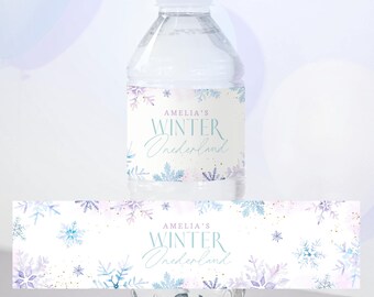 Peut inclure: Une bouteille d'eau en plastique transparent avec un bouchon blanc et une étiquette indiquant "AMELIA'S WINTER Wonderland". L'étiquette présente des flocons de neige aquarelle bleus et violets. Une étiquette assortie est en dessous.