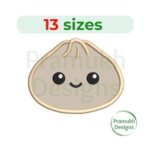 May include: An embroidered dumpling design with a smiling face and black eyes. The text "13 sizes" is above the dumpling, and the Pramukh Designs logo is in the lower right corner. The dumpling is beige with a light brown outline.