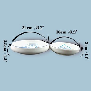 May include: Two white ceramic bowls with blue geometric designs. The larger bowl is 8.2 inches in diameter and 1.3 inches deep, while the smaller bowl is 6.2 inches in diameter and 1.1 inches deep. Both bowls have a blue rim.