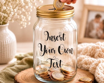 May include: A clear glass jar with a gold lid, filled with coins. The jar has the words "Insert Your Own Text" in black script. A hand is dropping a coin into the slot on the lid. The jar sits on a wooden slice.